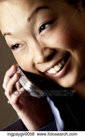 Close-up of a young woman talking on a mobile phone View Large Photo Image Stock Photo - Close-up of a young woman talking on a mobile phone. Fotosearch