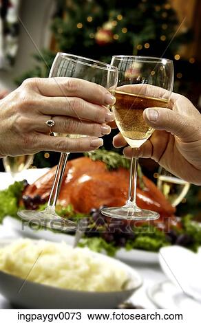 Stock Image - Close-up of the hands of a couple clinking from champagne glasses. Fotosearch