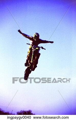 Low angle view of a man jumping in the air on a motorbike View Large Photo Image Stock Image - Low angle view of a man jumping in the air on a motorbike. Fotosearch