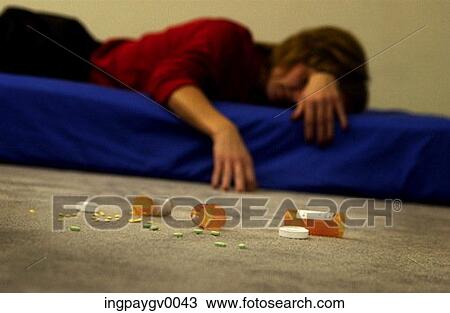 Mid adult woman sprawled on a mattress with vials of pills strewn on the floor View Large Photo Image Stock Image - Mid adult woman sprawled on a mattress with vials of pills strewn on the floor. Fotosearch