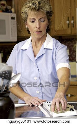 Mid adult woman wiping a grater with a kitchen rag View Large Photo Image Stock Image - Mid adult woman wiping a grater with a kitchen rag. Fotosearch