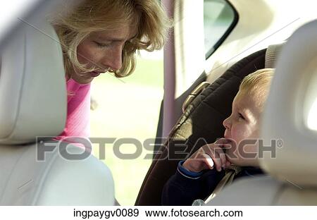 Mother looking at her son at the back seat of a car View Large Photo Image Stock Photo - Mother looking at her son at the back seat of a car. Fotosearch