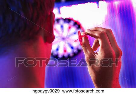 Stock Photo - Rear view of a young man holding a dart. Fotosearch