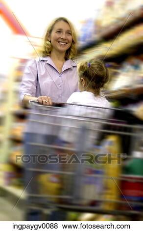 Woman pushing a shopping cart with a young girl View Large Photo Image Stock Photo - Woman pushing a shopping cart with a young girl. Fotosearch