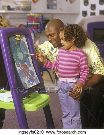 African American Father Watching His Daughter Paint In An Elementary School Classroom View Large Photo Image Stock Image - African American Father Watching His Daughter Paint In An Elementary School Classroom. Fotosearch
