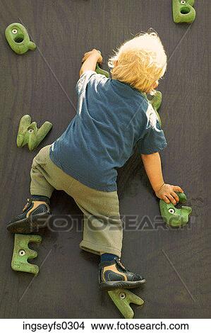 Picture - Boy Climbing Wall Of Letters. Fotosearch