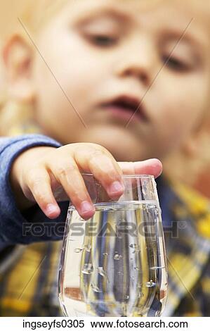 Stock Photography - Boy Touching Water Glass. Fotosearch