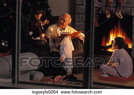 Picture - Grandpa Reading Christmas Story To Grandsons. Fotosearch