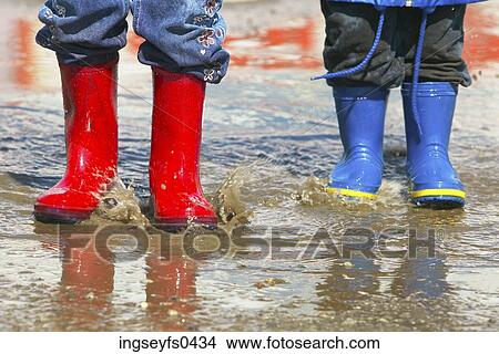 Picture - Kids Wearing Galoshes in a Puddle. Fotosearch