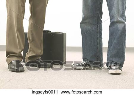 Stock Image - Legs in front of briefcase. Fotosearch