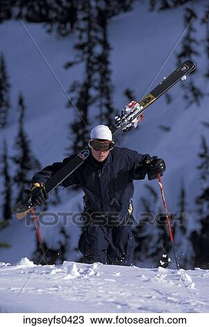 Stock Image - Man Climbing With Skies. Fotosearch