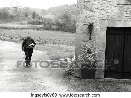 Stock Photo - Man Walking up Dirt Road. Fotosearch
