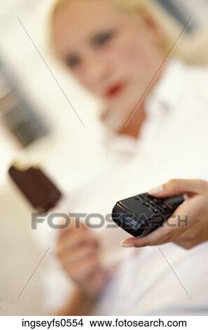 Woman Eating Eskimo Pie and Watching TV View Large Photo Image Picture - Woman Eating Eskimo Pie and Watching TV. Fotosearch
