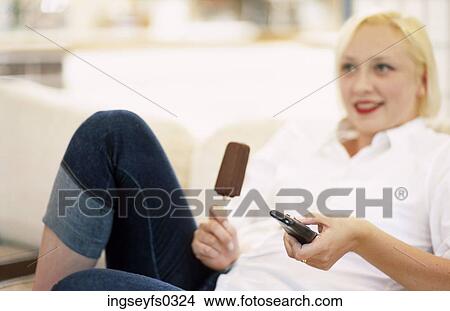 Woman Holding Ice Cream Bar And Remote Control View Large Photo Image Picture - Woman Holding Ice Cream Bar And Remote Control. Fotosearch