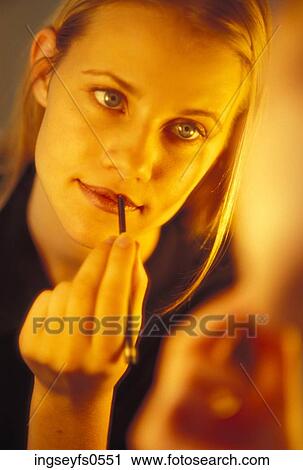 Stock Image - Woman Putting on Lipstick. Fotosearch
