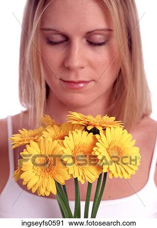 Stock Image - Woman Smelling Yellow Flowers. Fotosearch