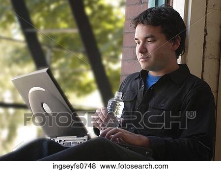 Young Man Typing at a Windowsill View Large Photo Image Stock Photo - Young Man Typing at a Windowsill. Fotosearch