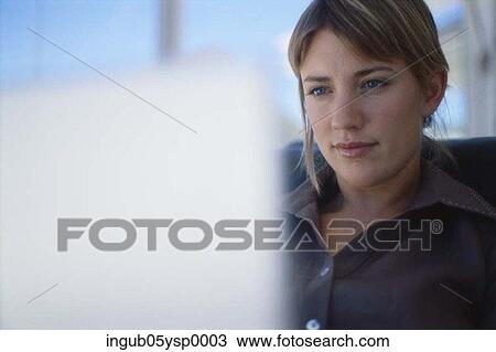 Businesswoman sitting in front of a computer View Large Photo Image Stock Image - Businesswoman sitting in front of a computer. Fotosearch