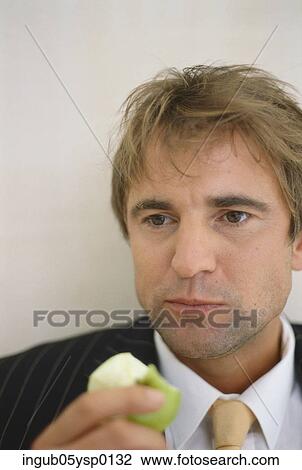 Close-up of a businessman eating an apple View Large Photo Image Stock Image - Close-up of a businessman eating an apple. Fotosearch