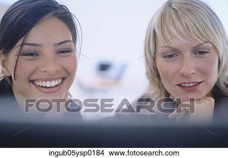 Close-up of a two young women looking at a computer screen View Large Photo Image Picture - Close-up of a two young women looking at a computer screen. Fotosearch