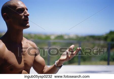 Stock Image - Close-up of a young man standing outdoors. Fotosearch