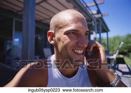 Stock Image - Close-up of a young man talking on a mobile phone. Fotosearch