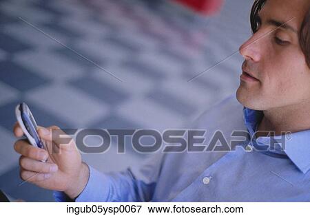 Stock Photo - Close-up of a young man using a mobile phone. Fotosearch
