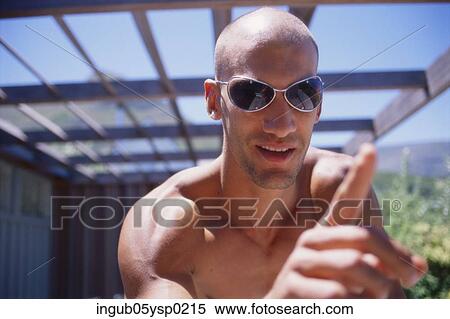 Close-up of a young man wearing sunglasses View Large Photo Image Stock Photography - Close-up of a young man wearing sunglasses. Fotosearch