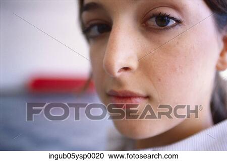 Stock Image - Close-up of a young woman looking at the camera. Fotosearch