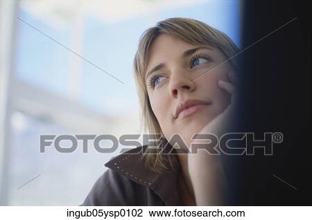 Close-up of a young woman sitting with her chin in her hand View Large Photo Image Stock Image - Close-up of a young woman sitting with her chin in her hand. Fotosearch