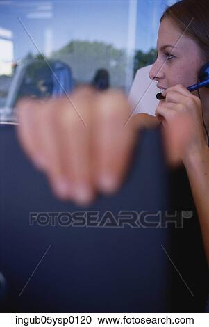 Close-up of a young woman wearing a headset View Large Photo Image Stock Image - Close-up of a young woman wearing a headset. Fotosearch