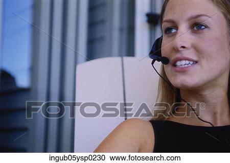 Close-up of a young woman wearing a headset View Large Photo Image Stock Image - Close-up of a young woman wearing a headset. Fotosearch