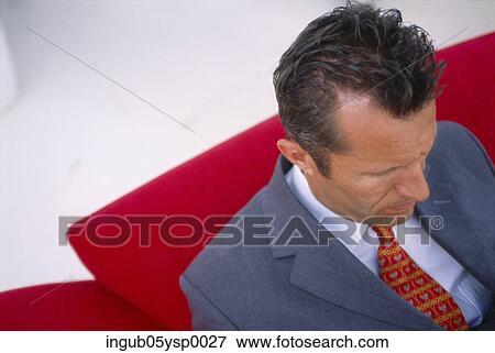 Stock Photo - High angle view of a businessman sitting on a couch. Fotosearch
