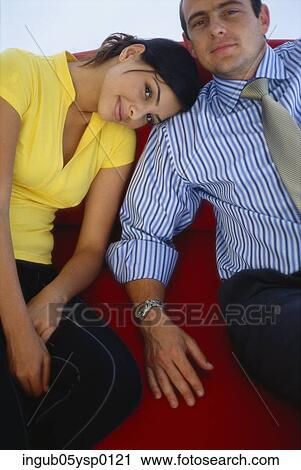 Stock Image - High angle view of a young couple sitting on a couch. Fotosearch
