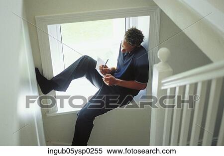 High angle view of a young m, an sitting in window ledge of a staircase View Large Photo Image Stock Photography - High angle view of a young m, an sitting in window ledge of a staircase. Fotosearch