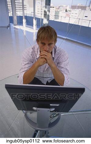 High angle view of a young man sitting in front of a computer View Large Photo Image Stock Image - High angle view of a young man sitting in front of a computer. Fotosearch