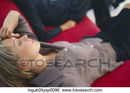 High angle view of a young woman lying on a couch View Large Photo Image Stock Photograph - High angle view of a young woman lying on a couch. Fotosearch