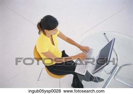 Stock Photo - High angle view of a young woman working on a computer. Fotosearch