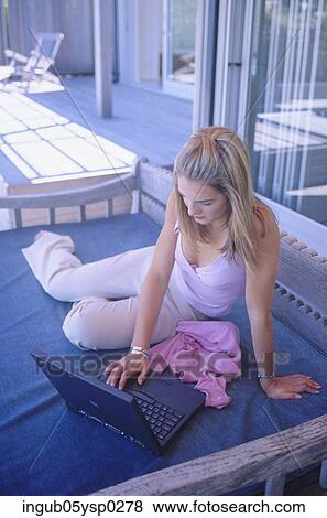 High angle view of a young woman working on a laptop View Large Photo Image Stock Photo - High angle view of a young woman working on a laptop. Fotosearch