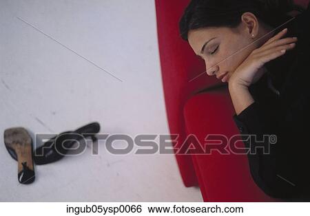 High angle view of a young woman sleeping on a couch View Large Photo Image Stock Photograph - High angle view of a young woman sleeping on a couch. Fotosearch