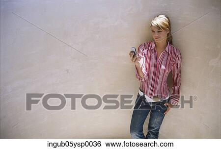 Stock Photograph - High angle view of a young woman using a mobile phone. Fotosearch