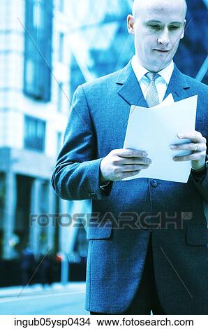 Low angle view of a businessman reading a document View Large Photo Image Picture - Low angle view of a businessman reading a document. Fotosearch