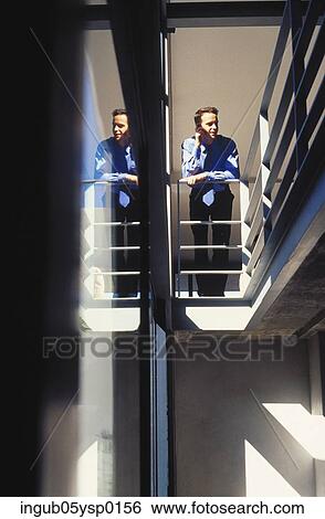 Stock Photograph - Low angle view of a businessman standing on a landing. Fotosearch