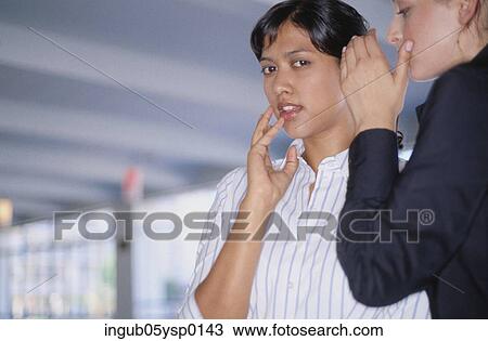 Low angle view of a two young women whispering to each other View Large Photo Image Stock Image - Low angle view of a two young women whispering to each other. Fotosearch