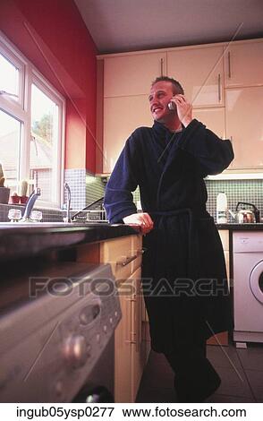 Low angle view of a young man standing in a kitchen View Large Photo Image Stock Photo - Low angle view of a young man standing in a kitchen. Fotosearch