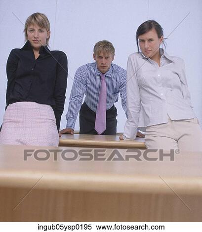 Low angle view of a young man standing between two young women View Large Photo Image Stock Photography - Low angle view of a young man standing between two young women. Fotosearch