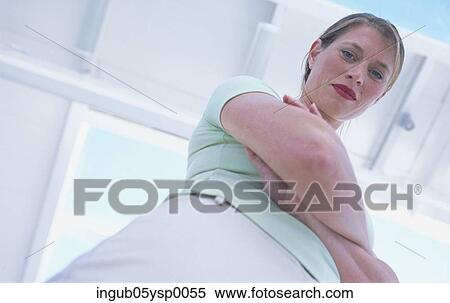 Stock Photography - Low angle view of a young woman looking at the camera. Fotosearch