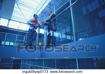 Low angle view of two businessmen talking on a landing View Large Photo Image Stock Image - Low angle view of two businessmen talking on a landing. Fotosearch