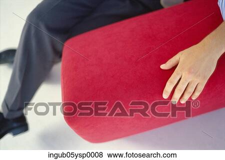 Low-section view of a person sitting on a couch View Large Photo Image Stock Photo - Low-section view of a person sitting on a couch. Fotosearch