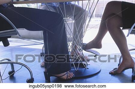 Low-section view of three people sitting at a table View Large Photo Image Stock Photo - Low-section view of three people sitting at a table. Fotosearch